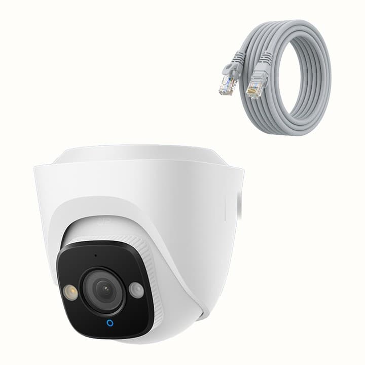 White dome shaped camera with a black lens block set into the front, beside a coiled grey network cable on a cream background